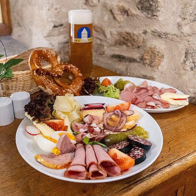 Brotzeitteller mit verschiedener Wurst- und Käseauswahl und Bier