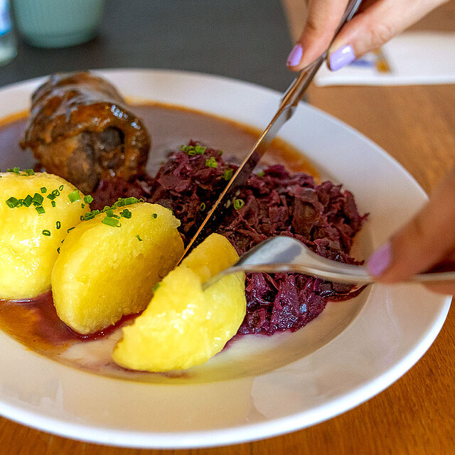Roulade mit Knödel wird angeschnitten