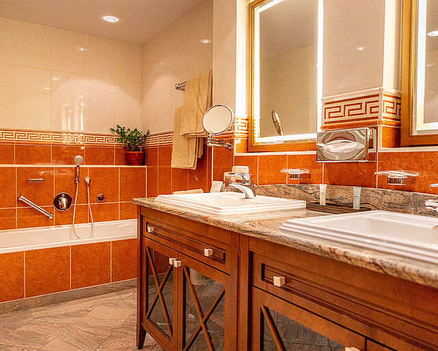 [Translate to English:] Geräumiges Badezimmer mit Badewanne und Doppelwaschtisch