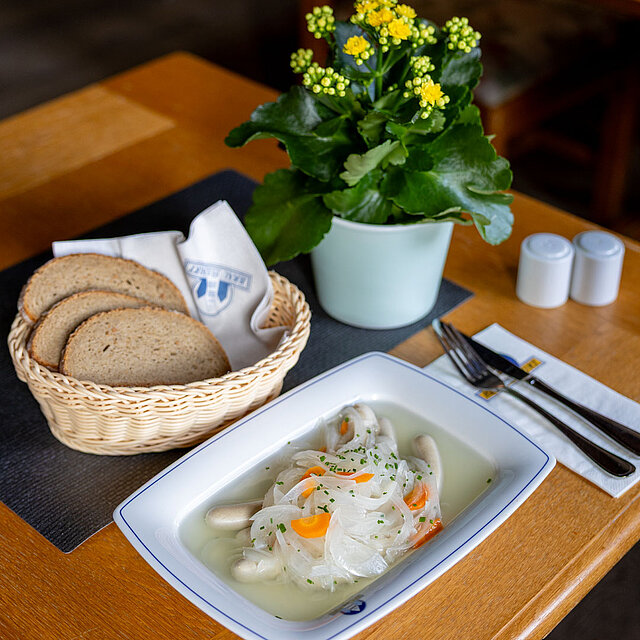 Sauere Bratwürste mit Brot und Zwiebelsud
